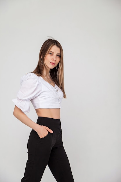 Casual portrait of pretty blonde young woman with hairstyle smiling cheerfully, showing emotion while feeling happy and carefree. Young cute cheerful girl looking at camera over white background