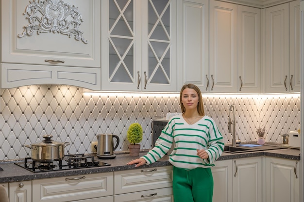 Casual portrait of young cute woman in the classic kitchen