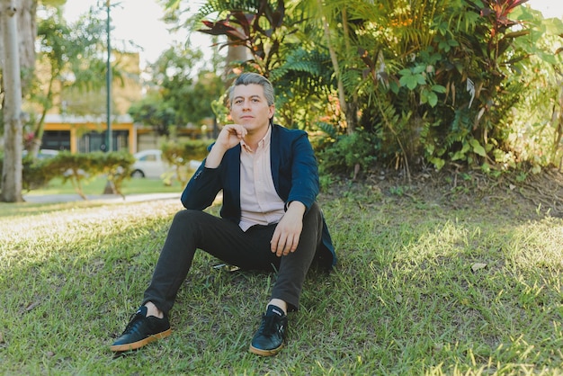 Casual portrait of young grayhaired man spending time in a garden