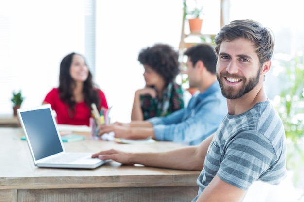 Casual smiling businessman looking at the camera