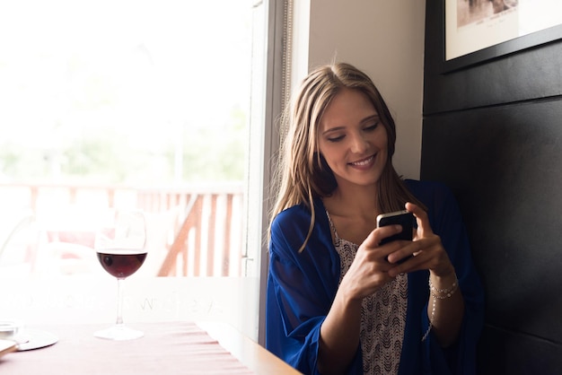 Casual woman using smartphone at coffee shop