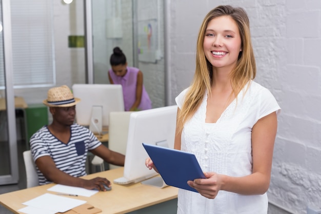 Casual woman with colleague using computer behind in office