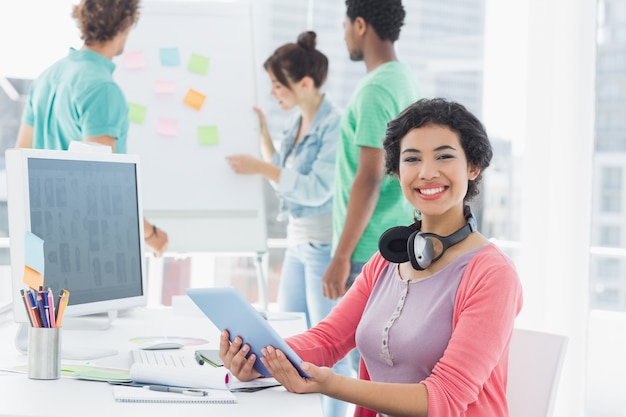 Casual woman with group of colleagues behind in office