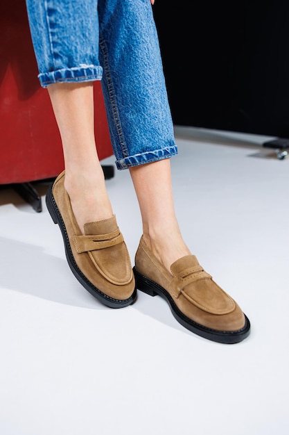 Photo casual women's fashion classic shoes for women slender female legs in trousers and brown stylish casual loafers women's comfortable summer shoes