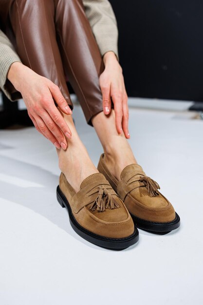 Casual women's fashion Classic shoes for women Slender female legs in trousers and brown stylish casual loafers Women's comfortable summer shoes