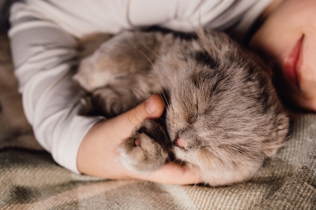 Cat and boy sleeping together hugged