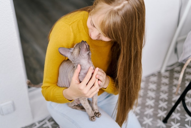 Cat and woman looking at each other taking care of gray kitty love and fun petrenthood