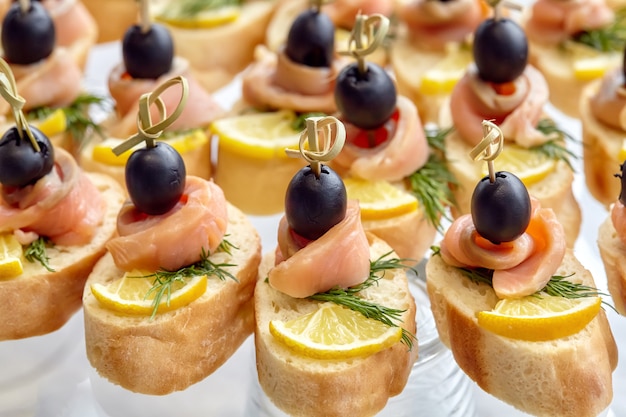 Catering of canape with olives, lemon and salmon