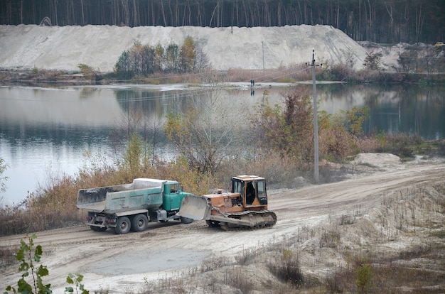 Caterpillar loader and dump truck work at the opencast mining quarry