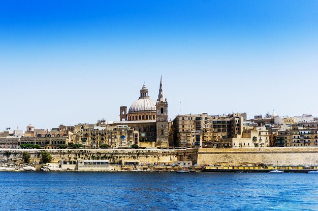 Cathedral and river in city against clear blue sky