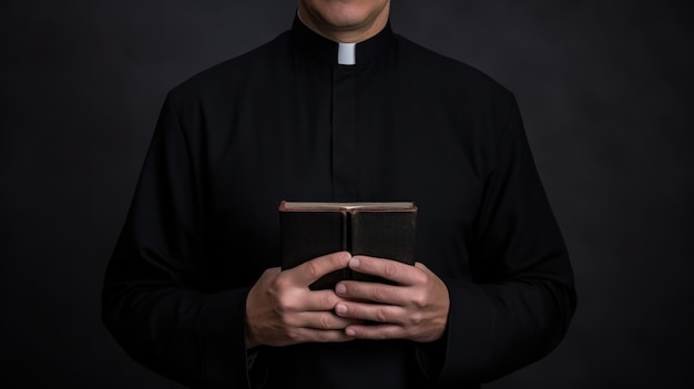 Catholic priest in black robe holds holy bible standing in old rural church closeup