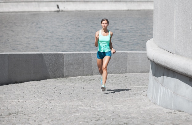 Caucasain sportswoman jogging uphill on the stone road