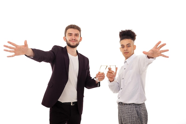 Caucasian and American male friends in formal wear celebrating a birthday holding champagne