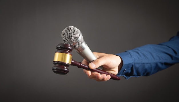 Caucasian auctioneer holding microphone and gavel