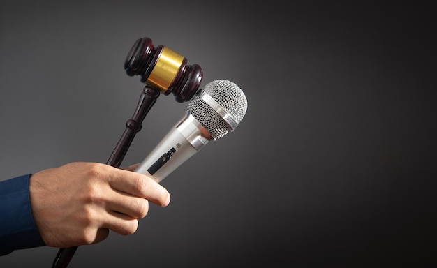 Caucasian auctioneer holding microphone and gavel