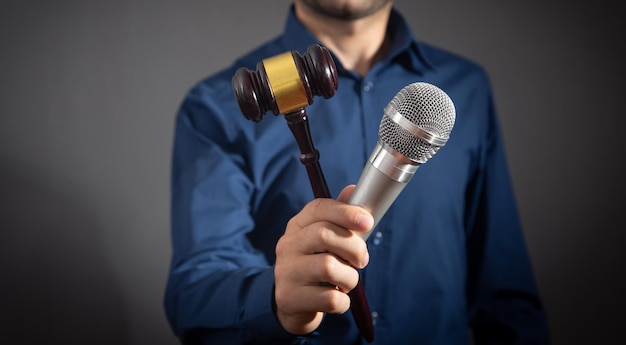 Caucasian auctioneer holding microphone and gavel