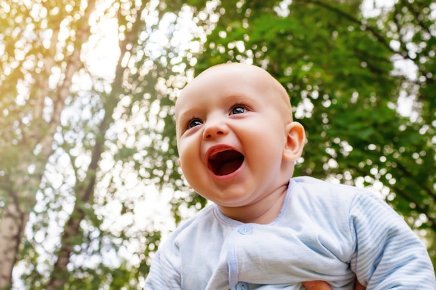 Caucasian baby boy flying in arms smiling