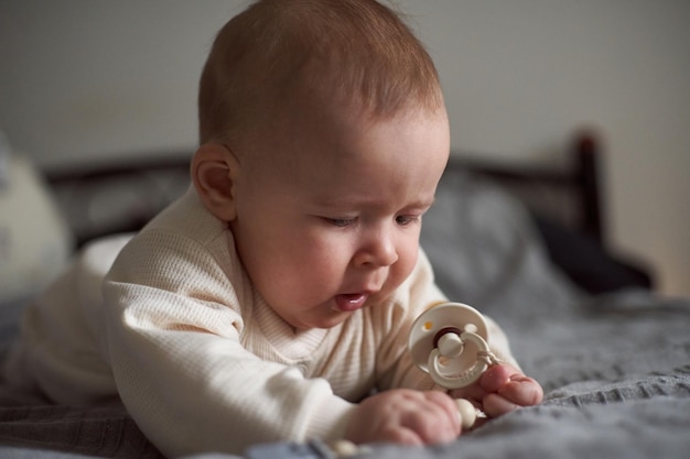 Caucasian baby boy lying on bed in the parents bedroom Pretty sixmonth old baby boy Realistic toddler home portrait