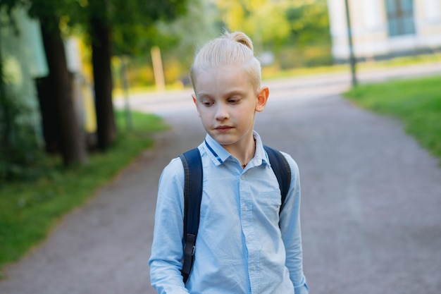 Caucasian boy walking from school wearing school bag Begining of academic year