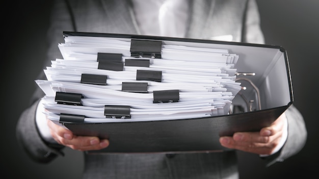 Caucasian businessman holding documents in office.