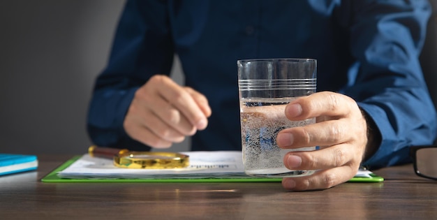 Caucasian businessman holding glass of water