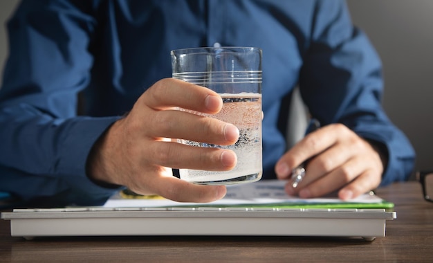 Caucasian businessman holding glass of water