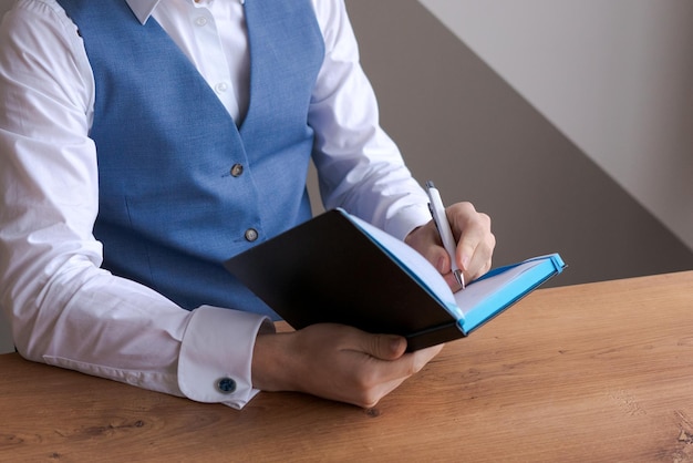 Caucasian businessman writing in notebook male hands holding pen making notes