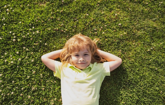 Caucasian child lying on grass Kids enjoying summer