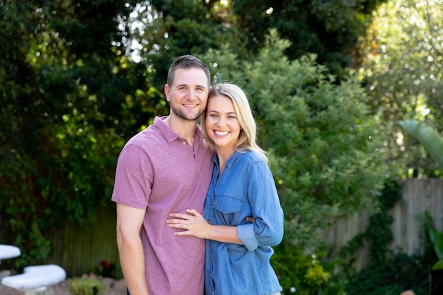 Photo caucasian couple spending time together in their garden, smiling and embracing. social distancing and self isolation in quarantine lockdown.