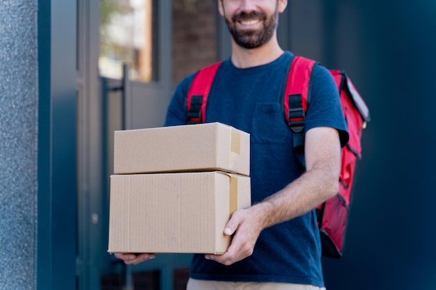 caucasian delivery man delivering parcel box. Courier service concept. horizontal view of happy rider delivering home a package.