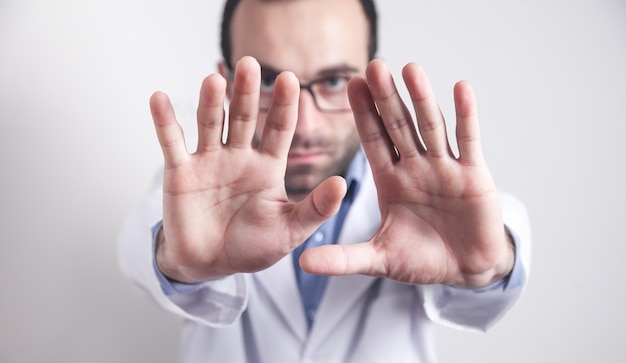 Caucasian doctor showing stop sign.