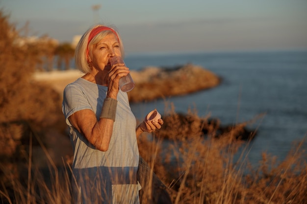 Caucasian elderly woman at daily fitness regime outdoors