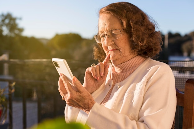 Caucasian elderly woman using a mobile phone outdoors