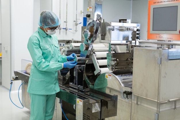 Caucasian factory worker in blue lab suit check readings of machine