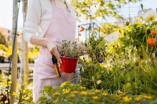 Caucasian female planting flowers in the backyard she taking care of the flowers in pots and posing