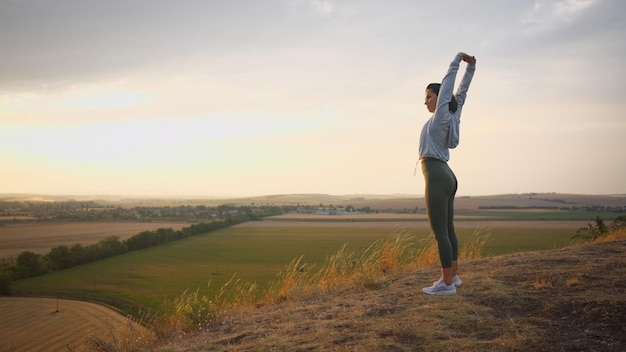 Caucasian female runner standing and warming up in preparation for a jogging run