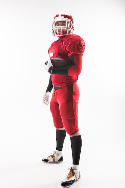 Caucasian fitness man as american football player holding a ball on white background