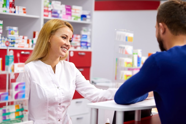 Caucasian friendly pharmacist has a nice conversation with a client