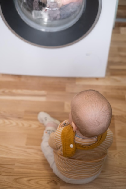 Caucasian girl playing with washing machine watching on a process