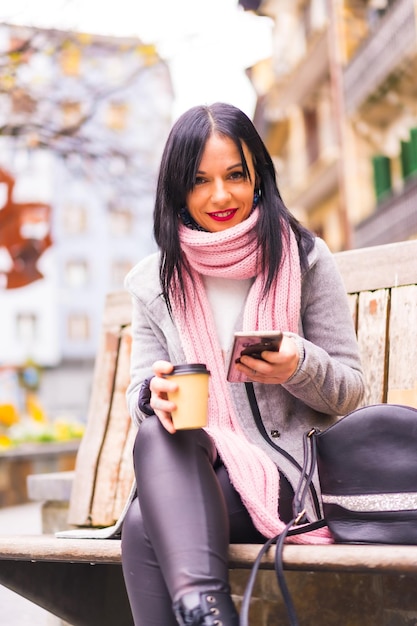 Caucasian girl shopping in the city with paper bags and a take away coffe