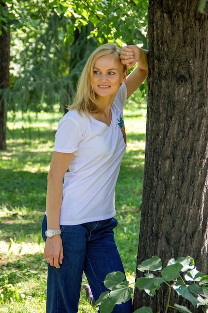 Caucasian girl walks in the park in warm weather outdoors