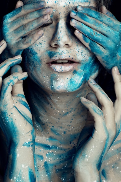 Caucasian girl with painted face in blue white flowers