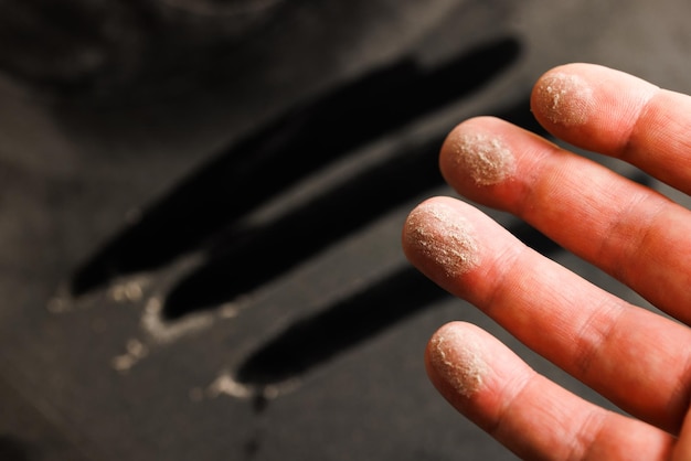 Caucasian hand with dust on finger tips after touching black dusty surface