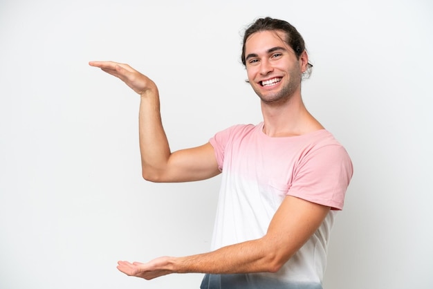 Caucasian handsome man isolated on white background holding copyspace to insert an ad