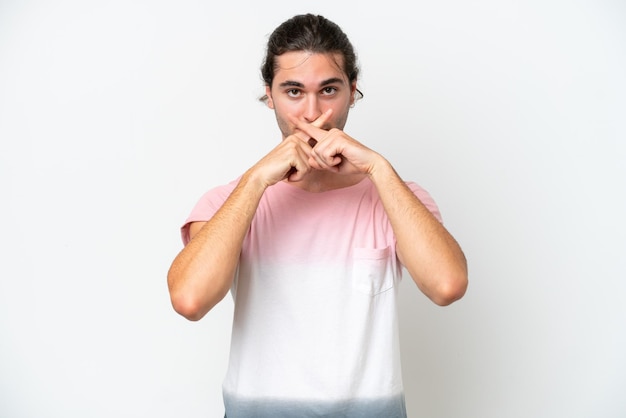 Caucasian handsome man isolated on white background showing a sign of silence gesture