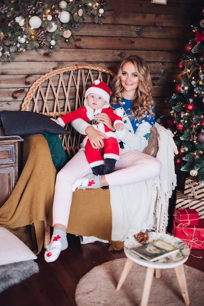 Caucasian little baby in christmas look spends christmas time with her mother