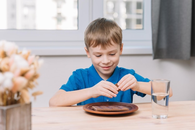 Caucasian little boy took a piece of chocolate to eat