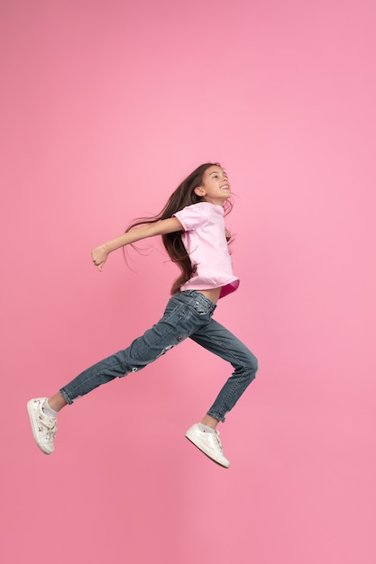 Caucasian little girl portrait isolated on pink studio background, emotions concept