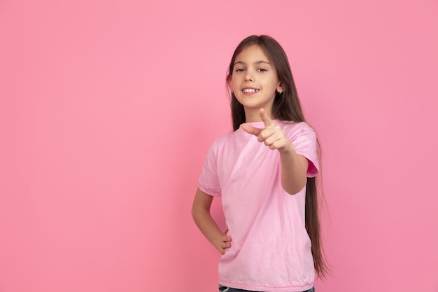 Caucasian little girl portrait isolated on pink studio, emotions concept