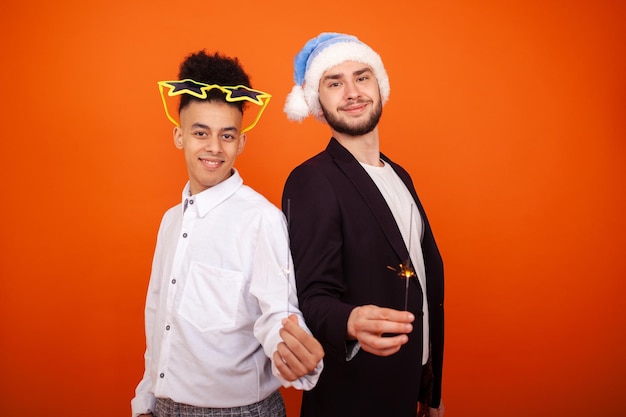 Caucasian male and African American men in formal wear with Santa hat and big star glasses